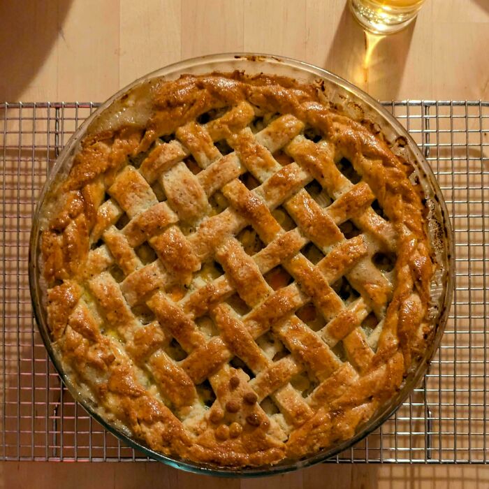 A golden lattice pie, fresh from the oven, showcasing savory baking mastery.