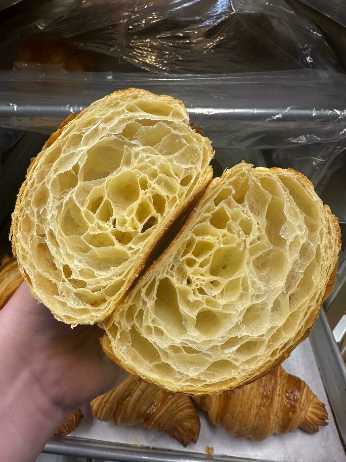 A golden croissant with buttery, flaky layers, showcasing expert baking techniques.