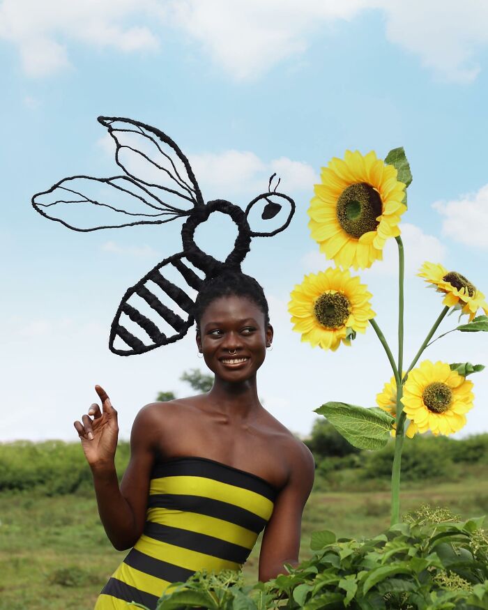Hair sculpture of a bee, buzzing near sunflowers in a striped dress.