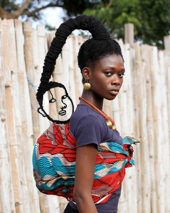 Intricate hair sculpture with vibrant details against colorful woven fabric.
