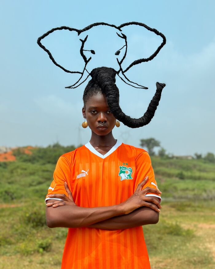 Hair sculpture of an elephant, paired with a bright orange jersey outdoors.