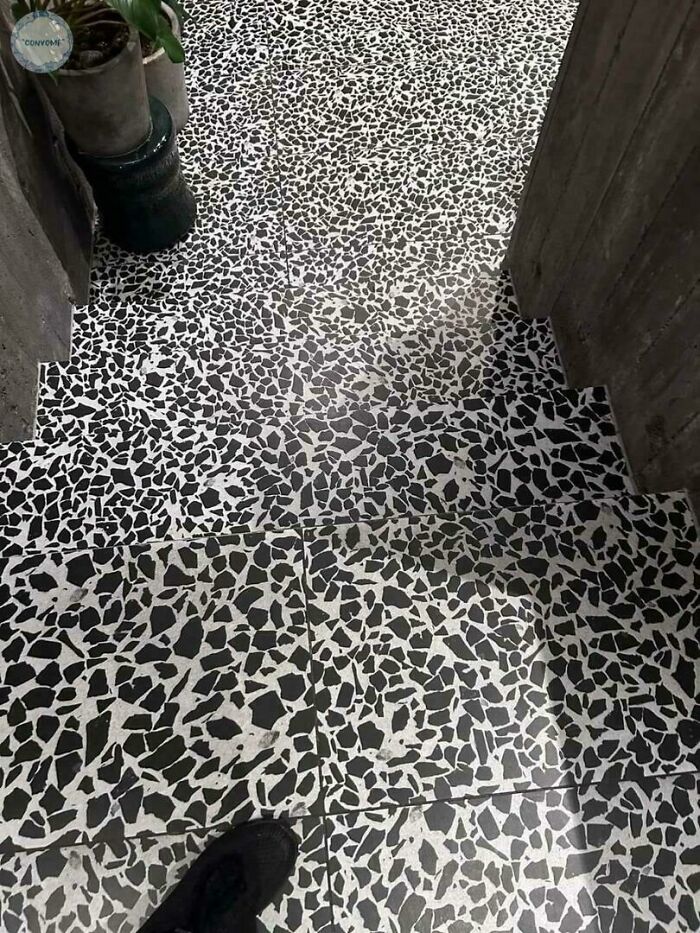 Stairs with black and white patterned tiles that create a dangerous design blending steps, posing a death trap risk.