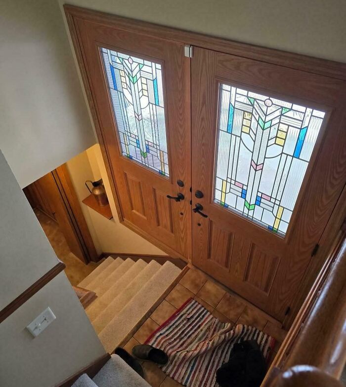 Staircase design with double front doors opening inward directly onto the stairs, a dangerous design and potential death trap.