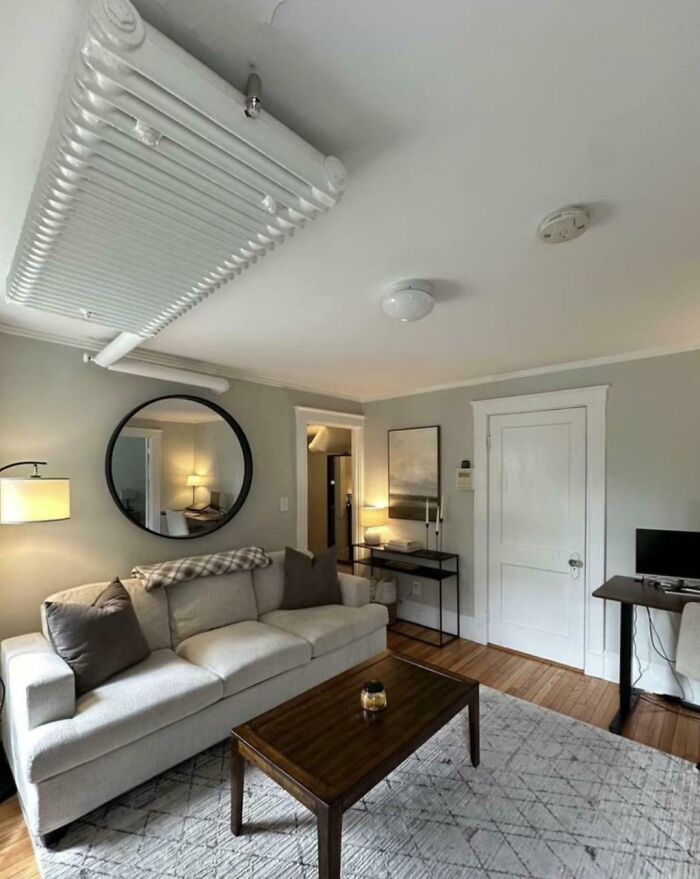 Living room with low ceiling radiator mounted above sofa, showing one of the dangerous designs that could be classified as death traps.