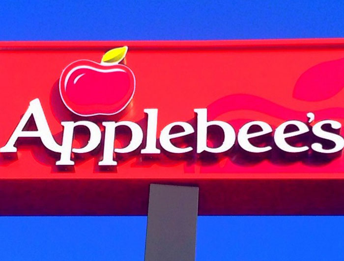 Applebee's restaurant sign against clear blue sky, related to chain restaurant employees' ordering warnings.