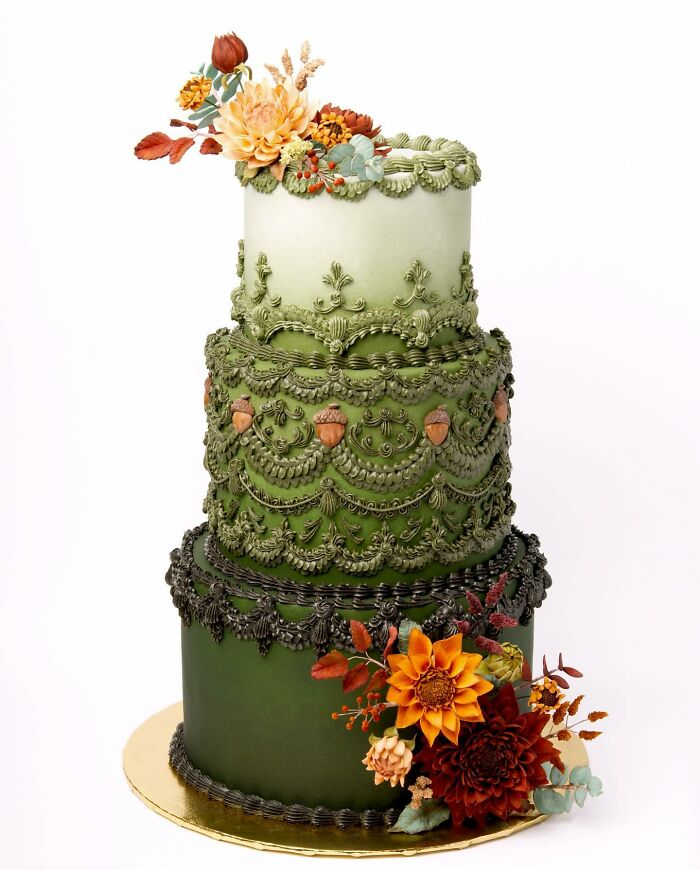 A vibrant vegan cake swirled with green icing, dotted with tiny acorns and bright blooms.