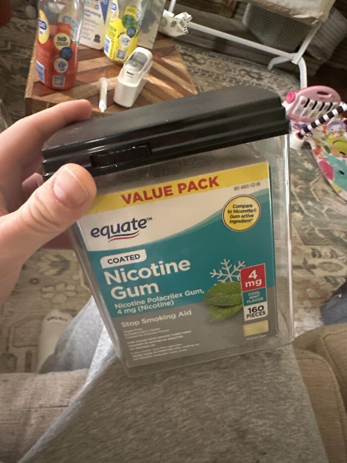 Hand holding a large container of nicotine gum with a black lid, illustrating unexpected fails and unfortunate fails.
