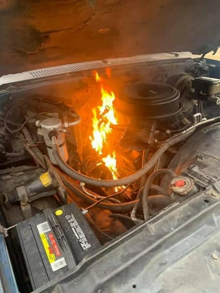 Car engine on fire showing an unexpected fail in the anything gone wrong group with flames inside the hood.
