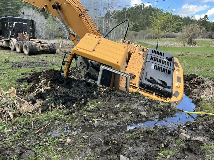 Excavator stuck in deep mud, showing one of the unexpected fails in an unfortunate construction site mishap.