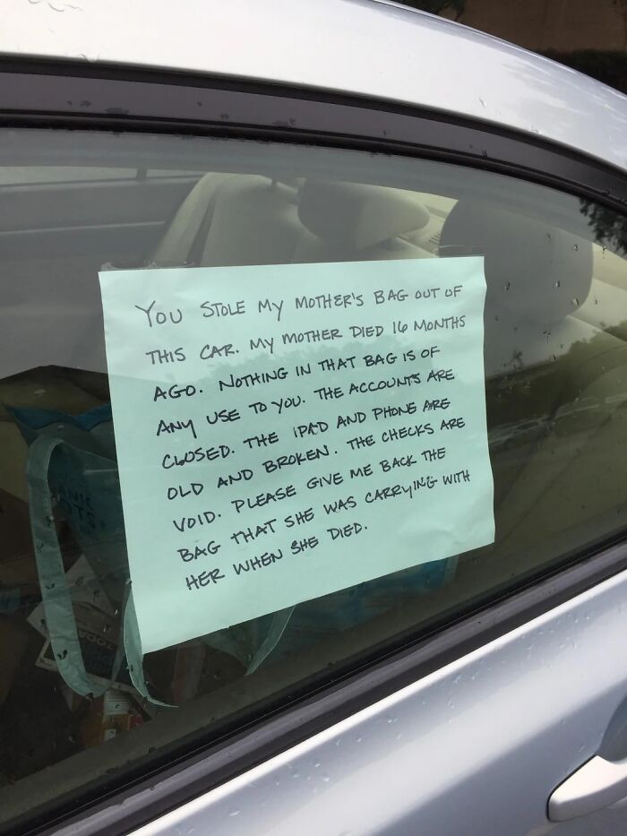 Note with a theft complaint taped to a car window, showcasing an unfortunate unexpected fail related to a stolen bag.
