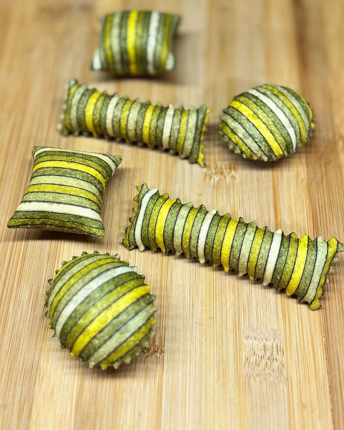 Handcrafted pasta in stripes of green, yellow, and white, showcasing a chef's colorful and patterned culinary artistry. Handcrafted pasta in stripes of green, yellow, and white, showcasing a chef's colorful and patterned culinary artistry.