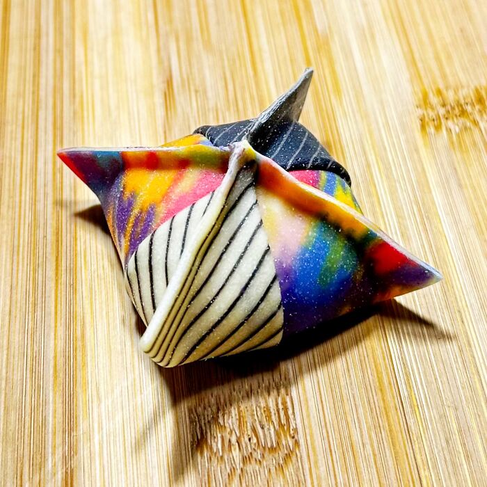 Colorful handcrafted pasta with vibrant patterns, crafted by a culinary artist on a wooden surface. Colorful handcrafted pasta with vibrant patterns, crafted by a culinary artist on a wooden surface.