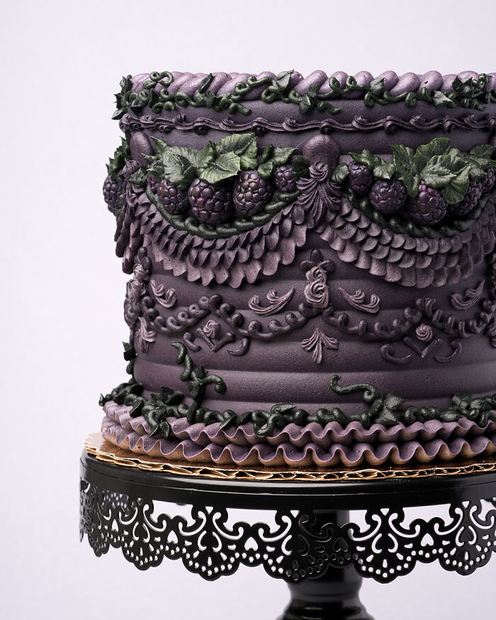 A quirky vegan cake with bug-inspired designs, rich purple icing, and lush green leaf accents.