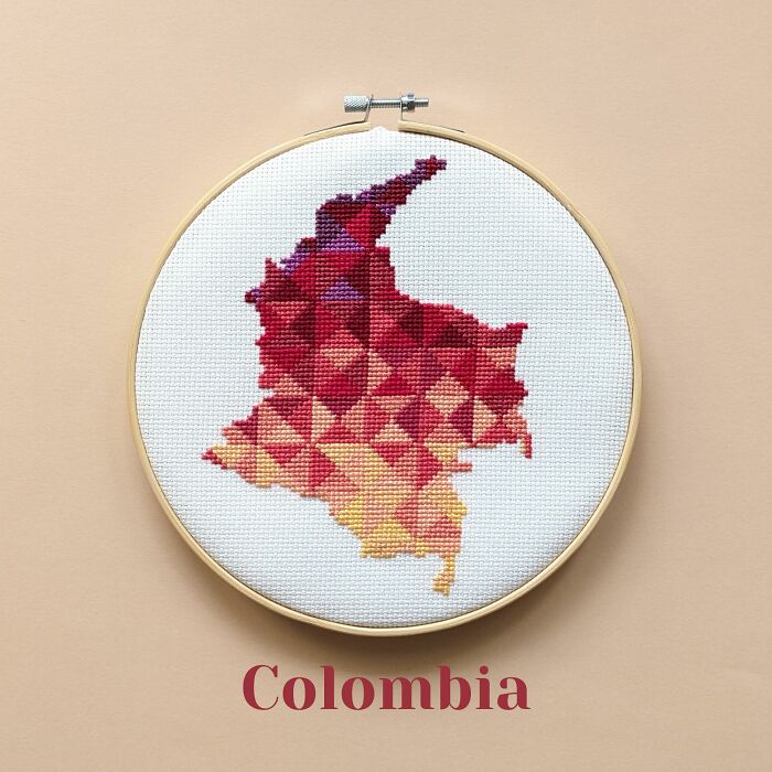 Colombia’s map in fiery reds and oranges, stitched with passion and framed in a hoop on a beige background.