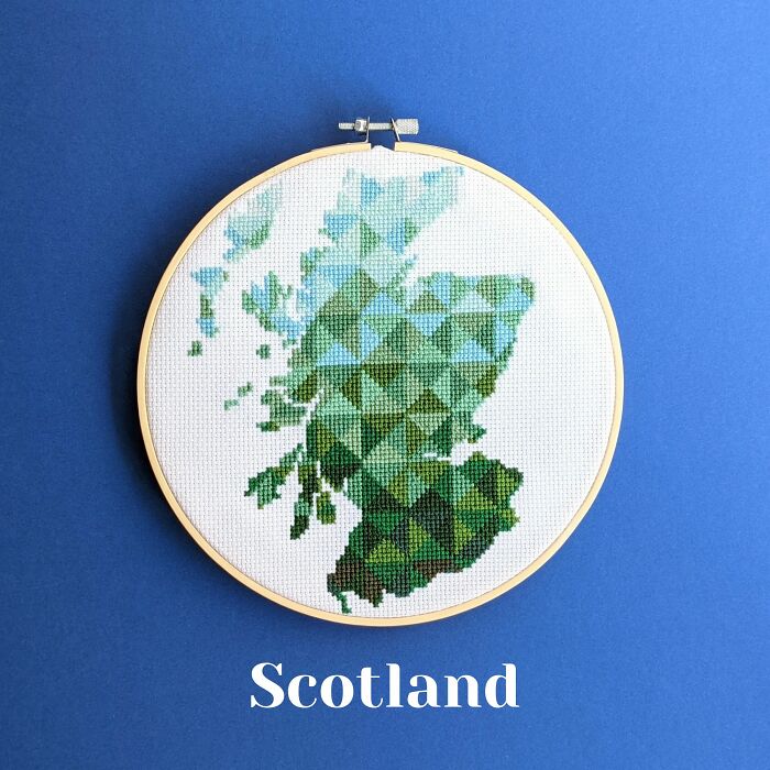 Scotland’s map in rich greens and blues, stitched with precision and framed in a hoop on a blue background.