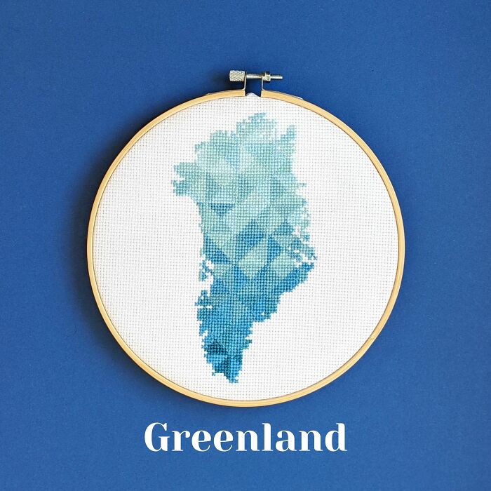 Greenland’s map in cool blue tones, stitched with care and framed in a hoop on a matching blue background.
