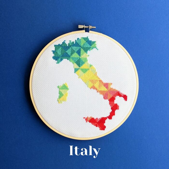 Italy’s map shines in a rainbow gradient, stitched with flair and framed in a hoop on a cool blue background.