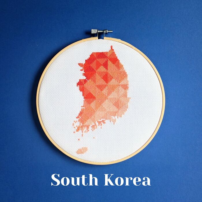 South Korea’s map glows in fiery reds and oranges, framed in a wooden hoop against a striking blue backdrop.