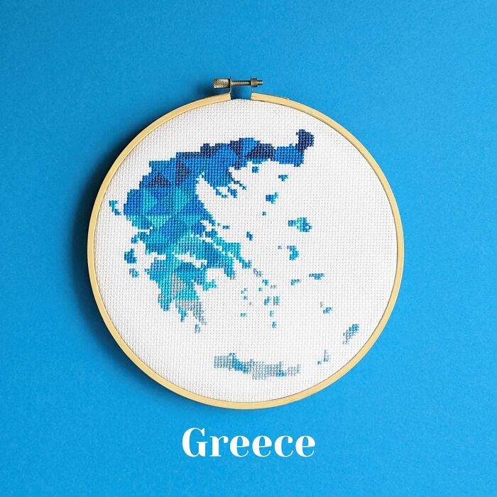 Greece’s map in vibrant blues, stitched with precision and framed in a hoop on a bright blue background.