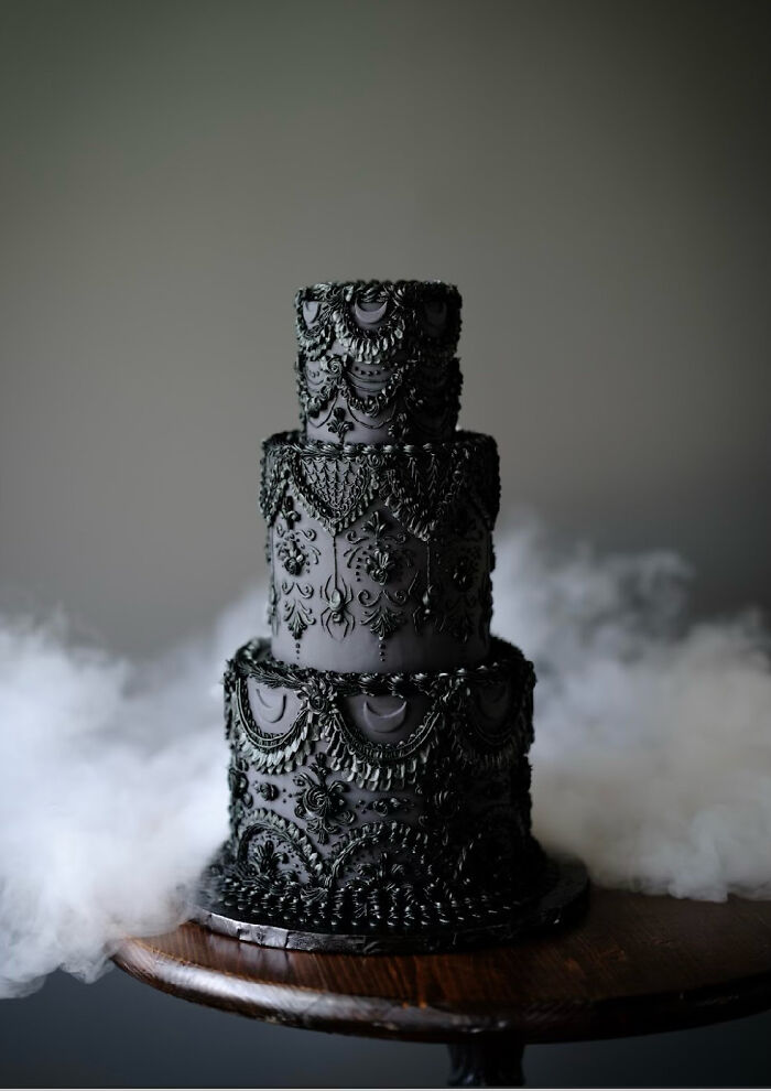 A dramatic vegan cake with bold black patterns, surrounded by a dreamy mist.
