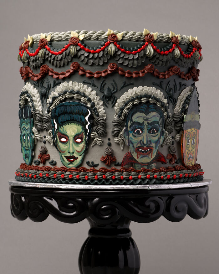 A spooky vegan cake with detailed monster faces, painted in bold gothic hues.